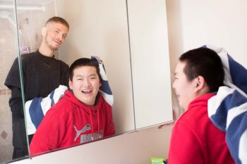 Male VON staff member washing the hair of young male client
