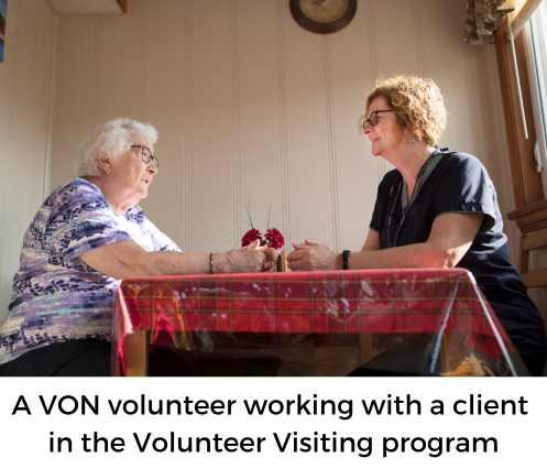 two woman sitting at a table, one a client, one a volunteer