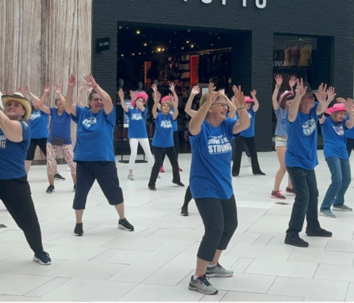 Group photo of SMART program staff and participants and loved one participating in a flash mob wearing VON BLUE