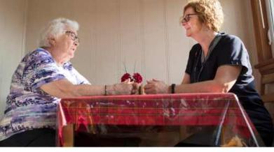 two woman sitting at a table, one a client, one a volunteer