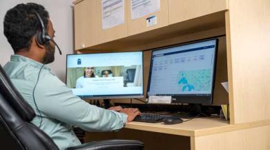 Man sitting at desk in front of two computer monitors