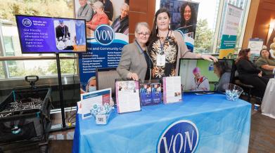 VON staff standing behind table at conference