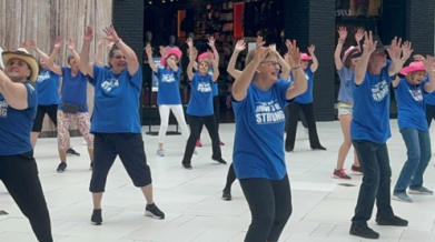 Group photo of SMART program staff and participants and loved one participating in a flash mob wearing VON BLUE 