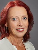 Headshot of Monique Porlier wearing a cream blouse with a flat grey background