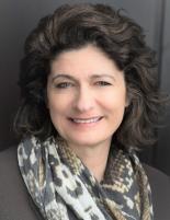 Headshot image of Valerie Carter, wearing a taupe floral scarf and a taupe blazer 